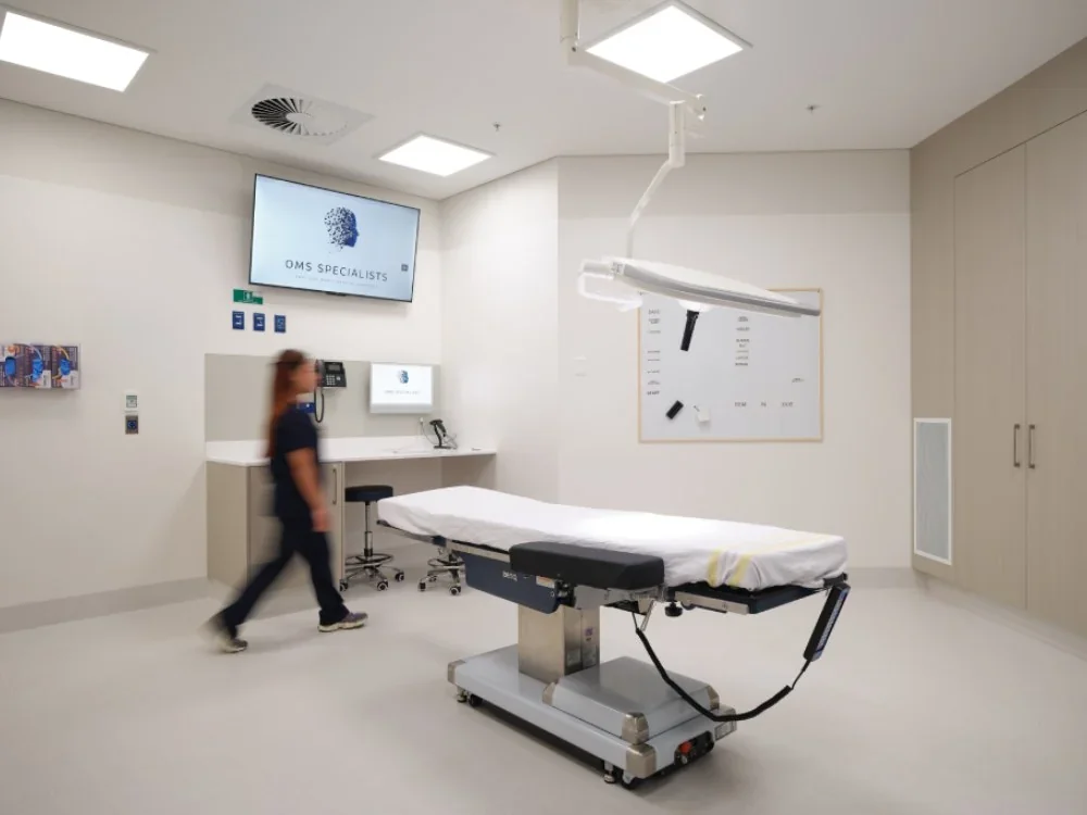 OMS Specialists operating theatre in Newmarket, a clinical staff member walking through the purpose-built surgical environment